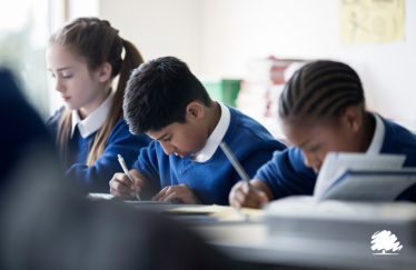 Children in a classroom completing an activity on a worksheet