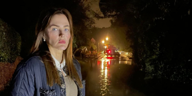 Marisa is standing in flooded water in Leigh. She looks very concerned, because the flood water is very dirty and ankle height.